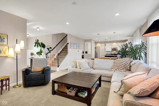 living room featuring stairway, recessed lighting, light colored carpet, and baseboards