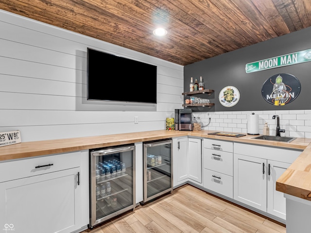 bar featuring wooden ceiling, wine cooler, and a sink