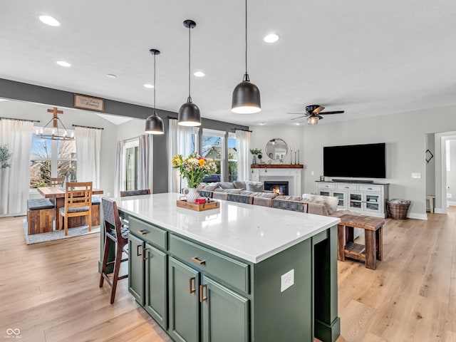 kitchen featuring a ceiling fan, a center island, recessed lighting, light wood-style floors, and green cabinetry