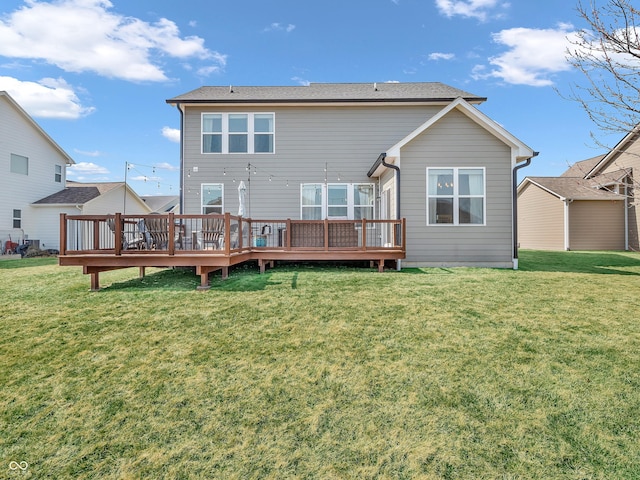 back of house featuring a wooden deck and a lawn