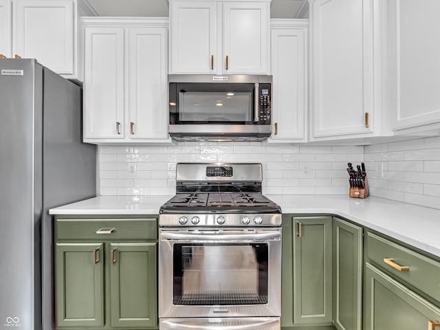 kitchen with green cabinetry, stainless steel appliances, decorative backsplash, light countertops, and white cabinets