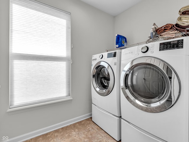 laundry area with light tile patterned floors, laundry area, washer and dryer, and baseboards