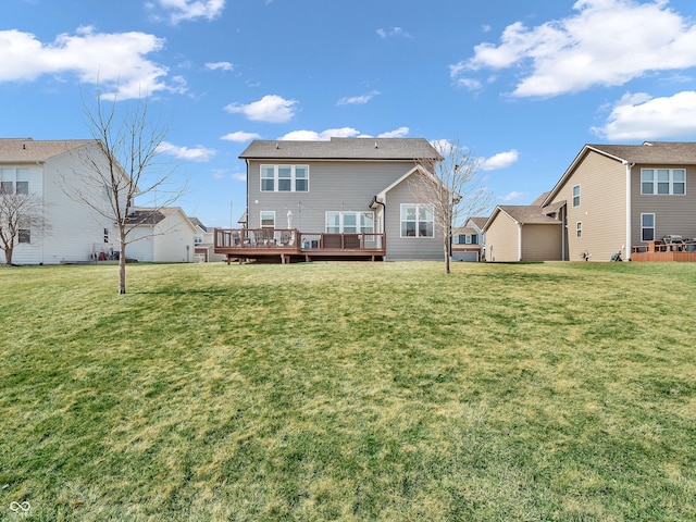 back of property with a yard and a wooden deck