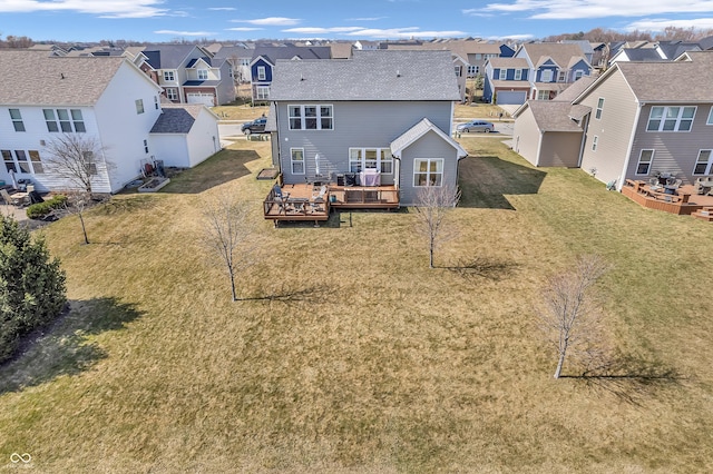 rear view of house featuring a residential view, a lawn, and a deck