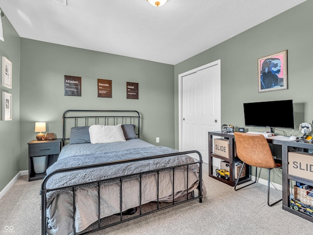 bedroom with a closet, baseboards, and carpet