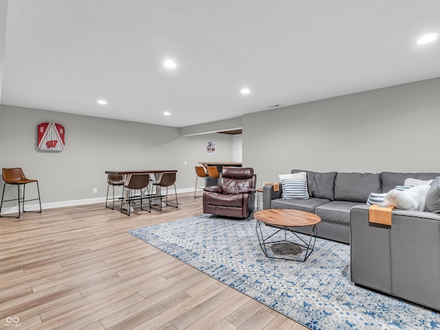 living area featuring recessed lighting, baseboards, wood finished floors, and a dry bar