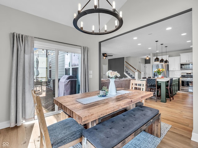 dining room featuring light wood finished floors, stairway, ceiling fan with notable chandelier, and recessed lighting