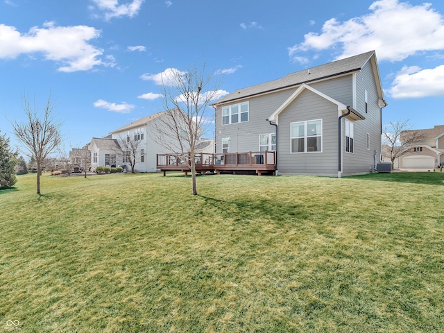 rear view of property with a wooden deck, a lawn, and cooling unit