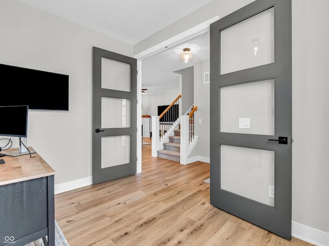 entrance foyer with visible vents, baseboards, stairs, and light wood-style floors