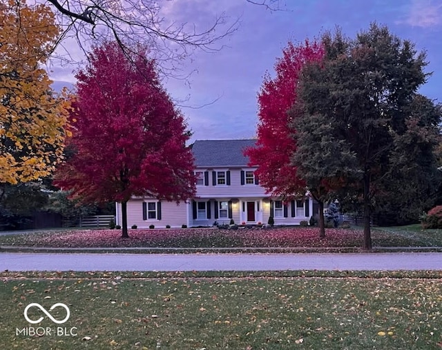 colonial home with a front lawn