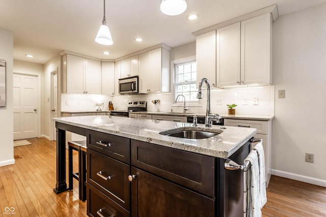 kitchen with white cabinetry, light wood finished floors, and appliances with stainless steel finishes