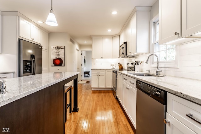 kitchen with visible vents, light wood-style flooring, a sink, appliances with stainless steel finishes, and white cabinetry