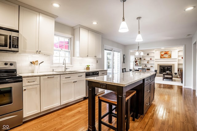 kitchen featuring appliances with stainless steel finishes, light wood-style floors, and a sink