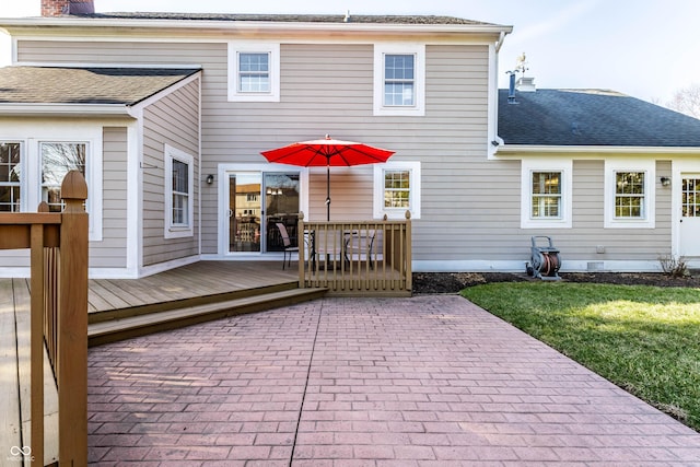 rear view of property featuring a lawn, a wooden deck, and a shingled roof