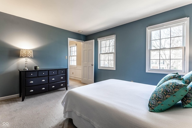 bedroom with light colored carpet and baseboards