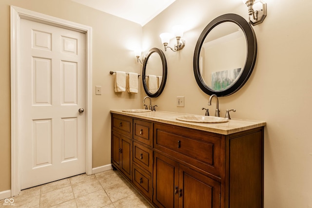 bathroom with a sink, baseboards, double vanity, and tile patterned floors