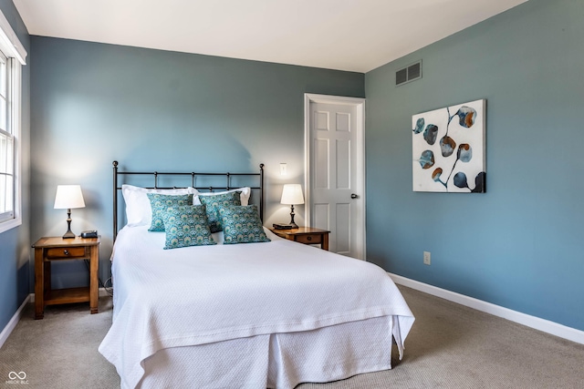 bedroom featuring visible vents, carpet floors, multiple windows, and baseboards