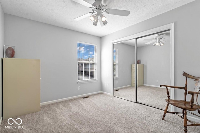 unfurnished bedroom with a closet, visible vents, carpet floors, and a textured ceiling