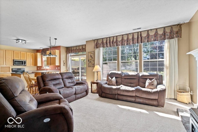 living room with light colored carpet, visible vents, and a textured ceiling