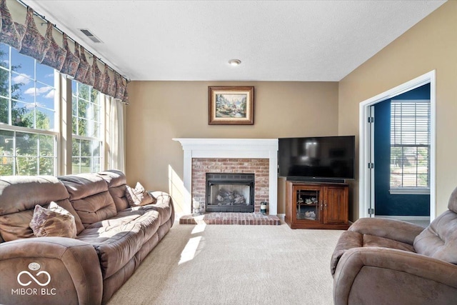 living room with visible vents, a brick fireplace, carpet, and a healthy amount of sunlight