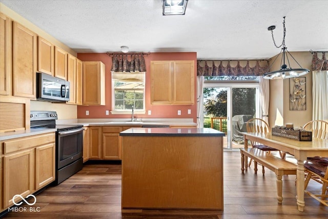 kitchen featuring stainless steel appliances, a kitchen island, dark wood-style floors, and a textured ceiling