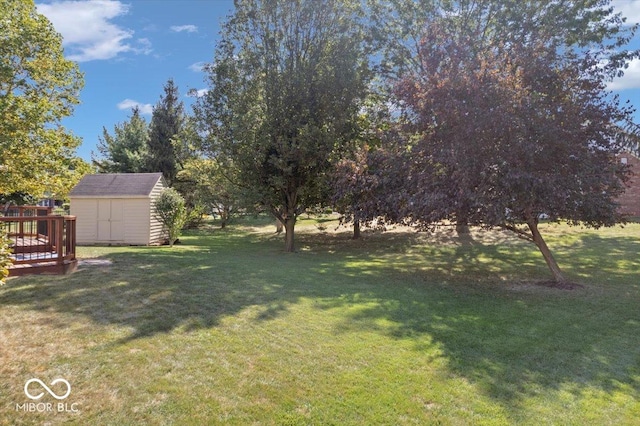 view of yard featuring a shed, a wooden deck, and an outdoor structure