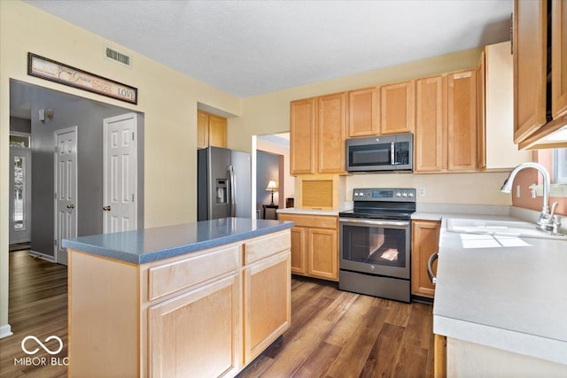 kitchen featuring light brown cabinets, visible vents, appliances with stainless steel finishes, and a sink