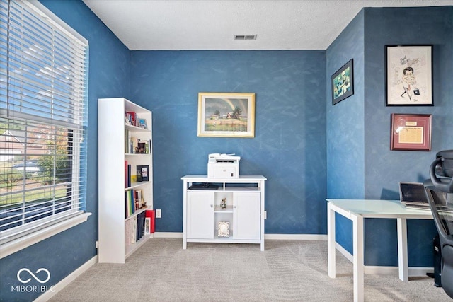 carpeted home office featuring visible vents, baseboards, and a textured ceiling