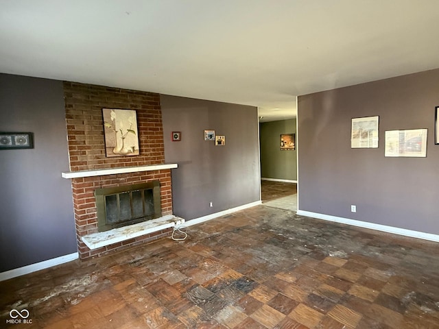 unfurnished living room with baseboards and a brick fireplace