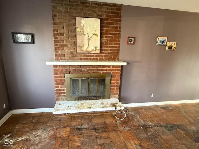 interior details with wood finished floors, a fireplace, and baseboards