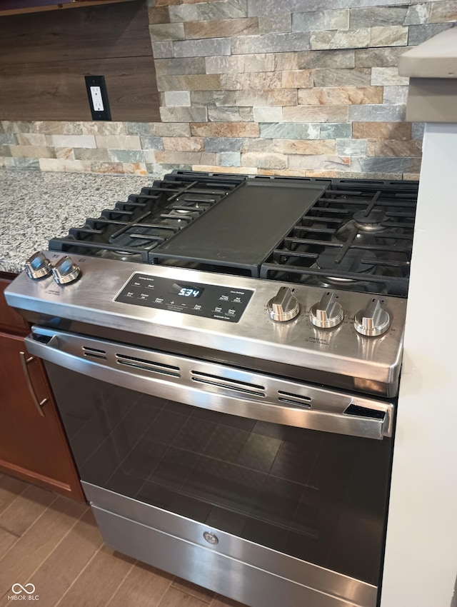 5603 S Randolph St, Indianapolis, IN 46227 - interior details with light countertops, stainless steel gas range, wood finished floors, and backsplash