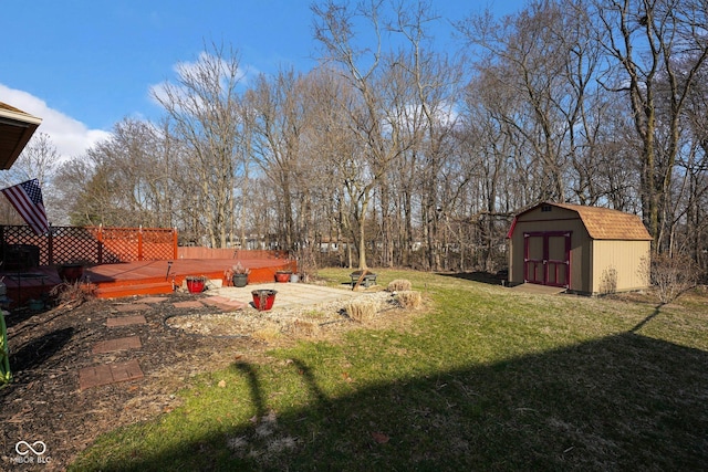 view of yard featuring a wooden deck, a storage shed, and an outdoor structure