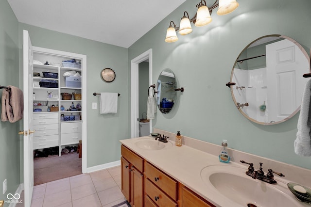 full bathroom featuring a sink, a walk in closet, double vanity, and tile patterned floors