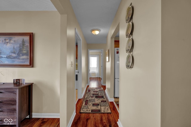 hallway featuring baseboards and wood finished floors