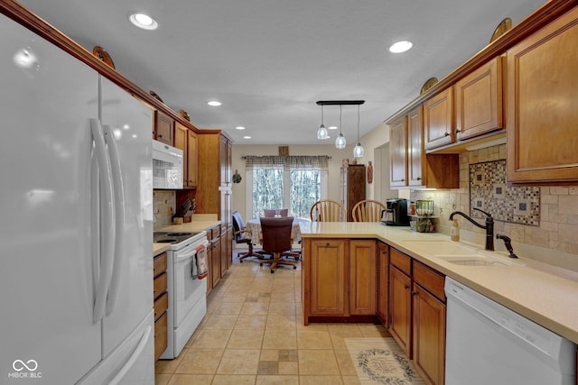 kitchen featuring a sink, white appliances, a peninsula, and light countertops