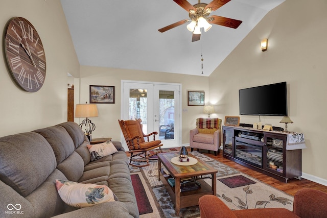 living area featuring baseboards, french doors, wood finished floors, high vaulted ceiling, and a ceiling fan