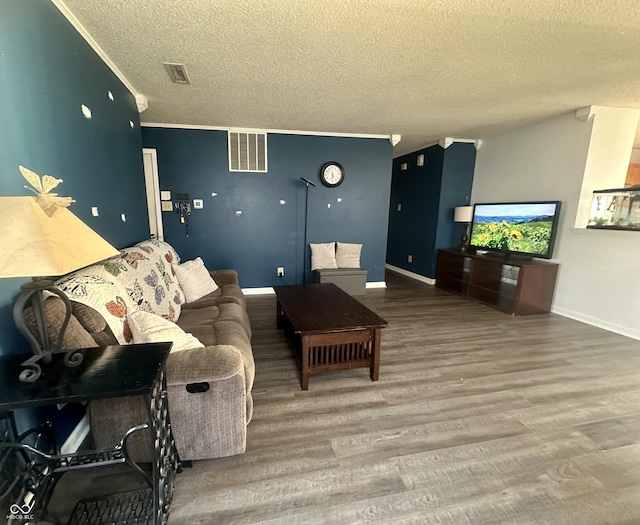 living area featuring visible vents, a textured ceiling, crown molding, and wood finished floors