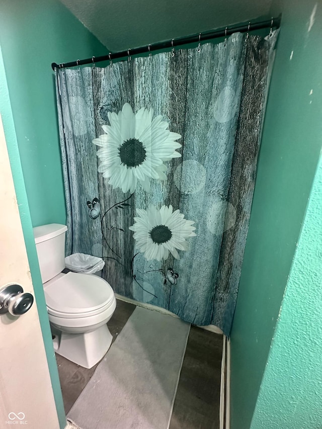 bathroom featuring a shower with shower curtain and toilet