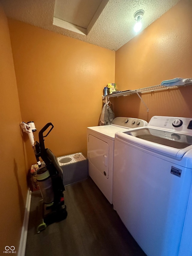 washroom with washer and clothes dryer, a textured ceiling, laundry area, attic access, and dark wood-style flooring