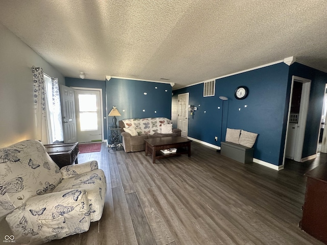 living area with visible vents, a textured ceiling, baseboards, and wood finished floors