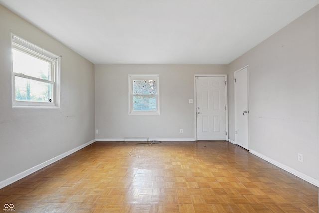 spare room with plenty of natural light and baseboards