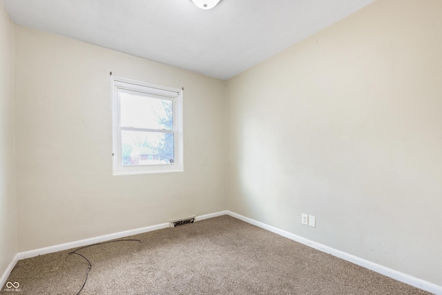 carpeted empty room featuring visible vents and baseboards