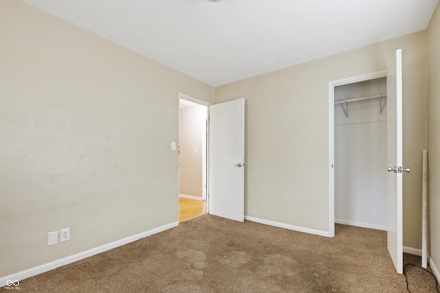 unfurnished bedroom featuring a closet, baseboards, and carpet floors