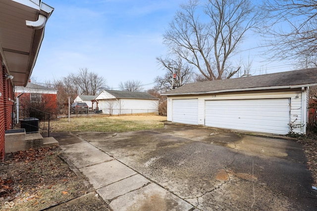 detached garage featuring central AC and fence