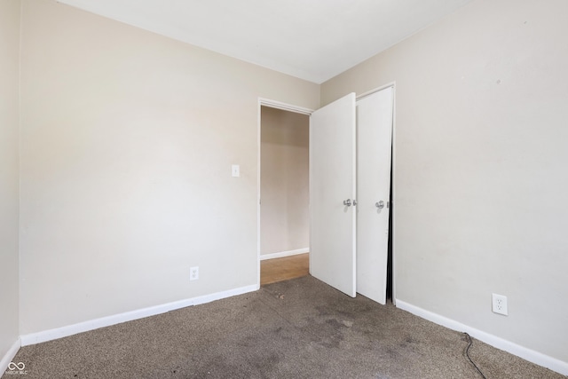 spare room featuring baseboards and carpet