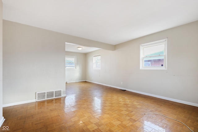 unfurnished room featuring baseboards and visible vents