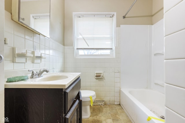 full bath featuring vanity, toilet, tile walls, and  shower combination