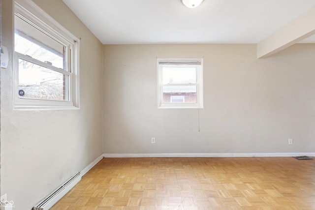 spare room with a baseboard heating unit and baseboards