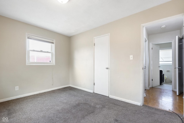 unfurnished bedroom with carpet flooring and baseboards