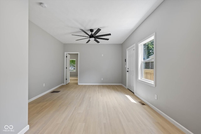 empty room with visible vents, baseboards, light wood-style flooring, and a ceiling fan